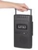 main qui transporte un lecteur de cassettes